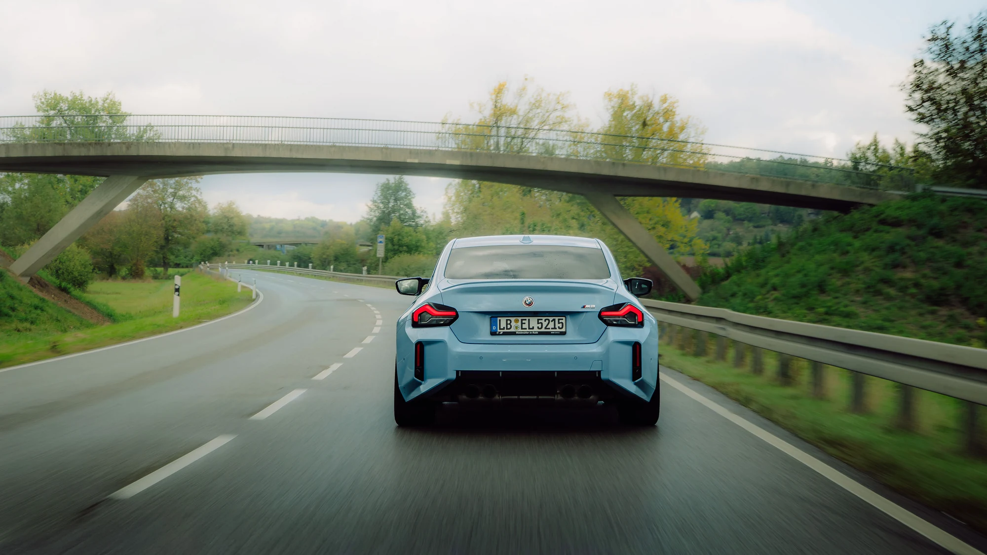 Blauer Sportwagen unterwegs durch eine Kurve