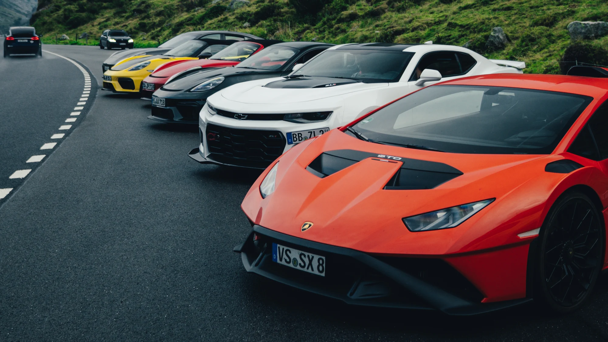Lamborghini Huracán STO und Porsche beim Tourstopp an einer Alpenstraße
