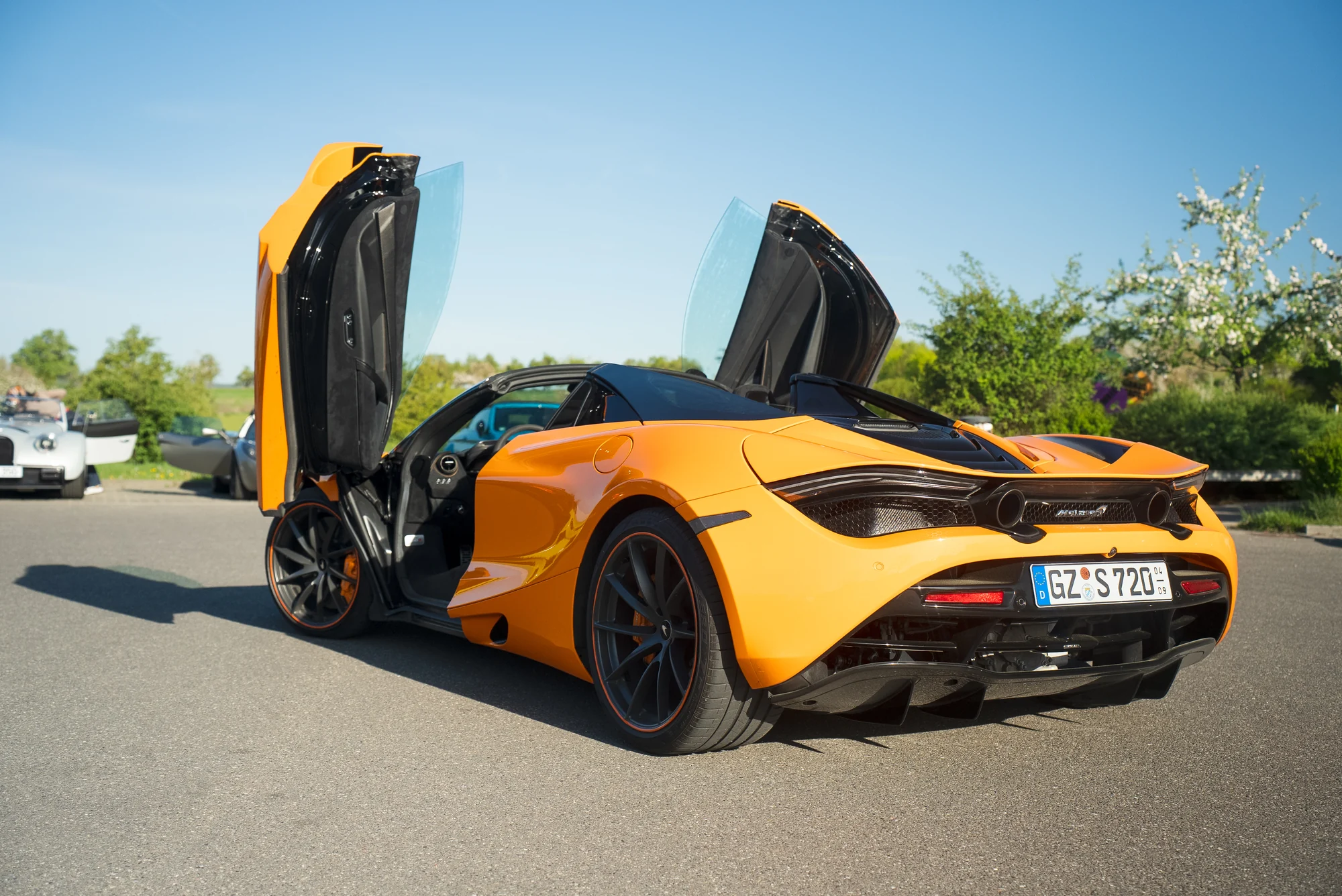Orangefarbener McLaren mit geöffneten Türen