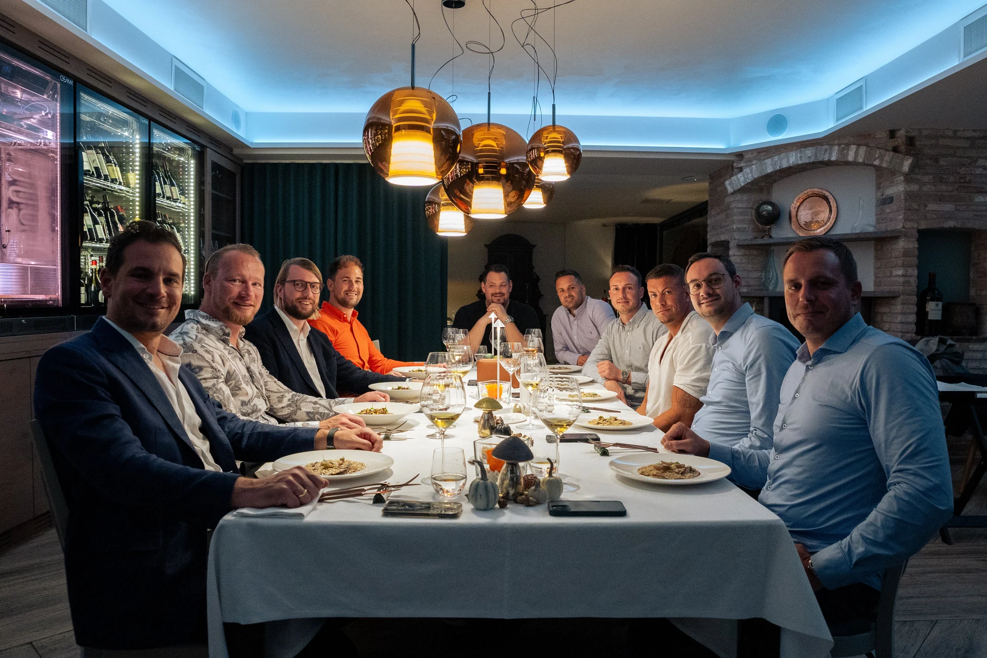 Teilnehmer im gehobenen Restaurant an einer gemeinsam gedeckten Tafel