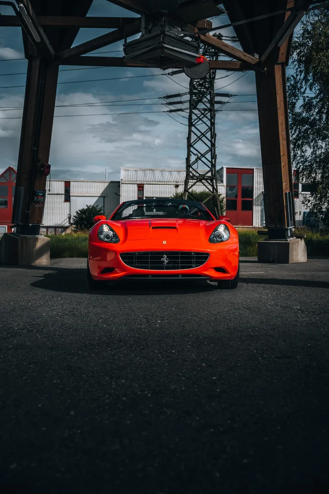 Roter Ferrari beim Tourstopp vor einer Industriehalle