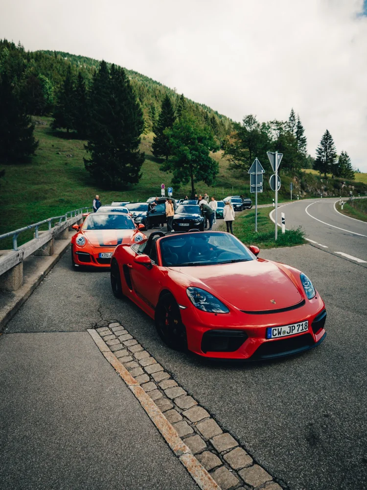 Rote und orangefarbene Sportwagen am alpinen Tourstopp