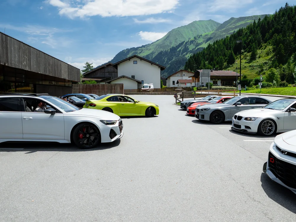 Sportwagen beim gemeinsamen Stopp vor dem Alpenpanorama