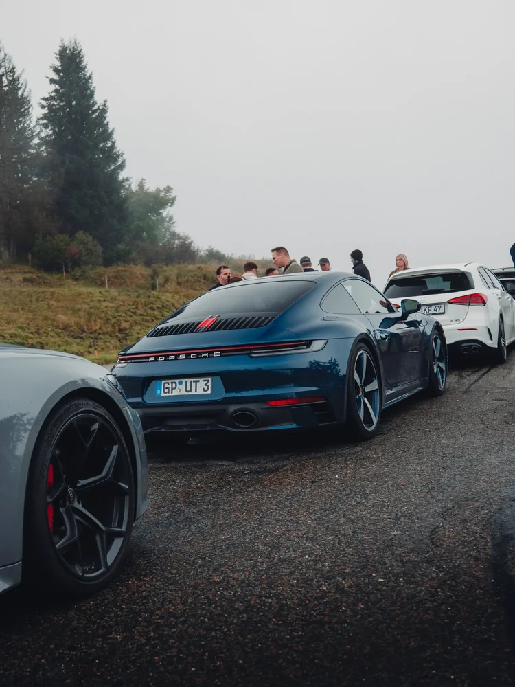 Dunkler Porsche beim nebligen Tourstopp