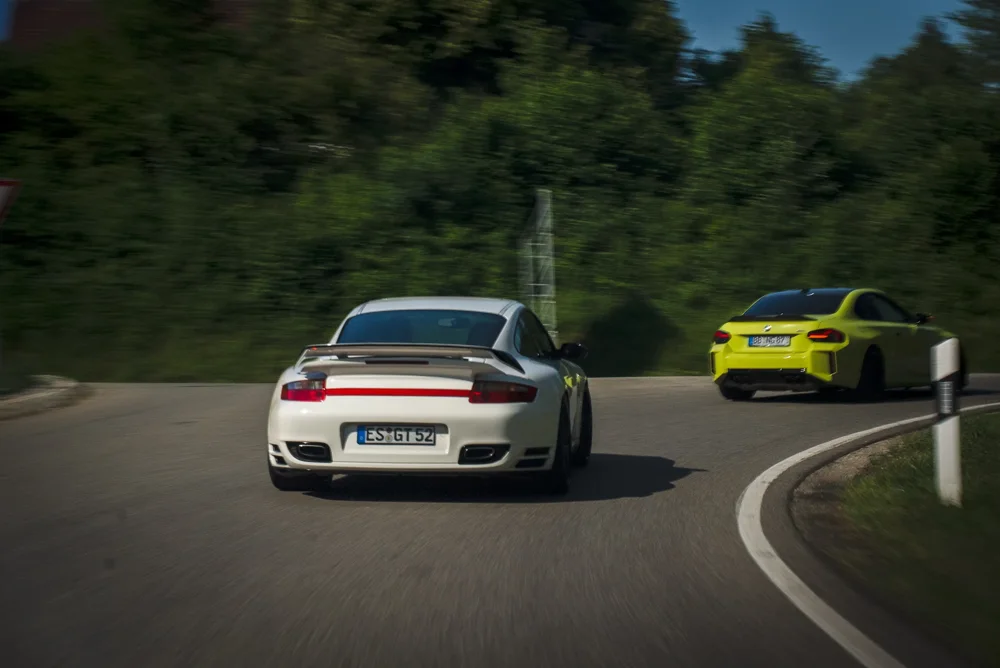 Zwei Porsche unterwegs auf einer kurvigen Straße