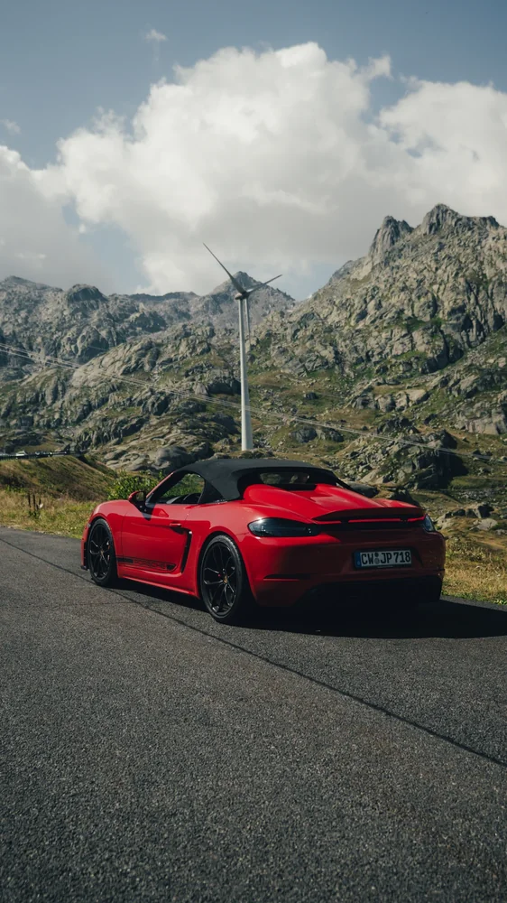 Roter Porsche Spyder vor alpiner Bergkulisse