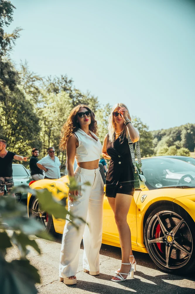 Zwei Teilnehmerinnen vor einem gelben Porsche