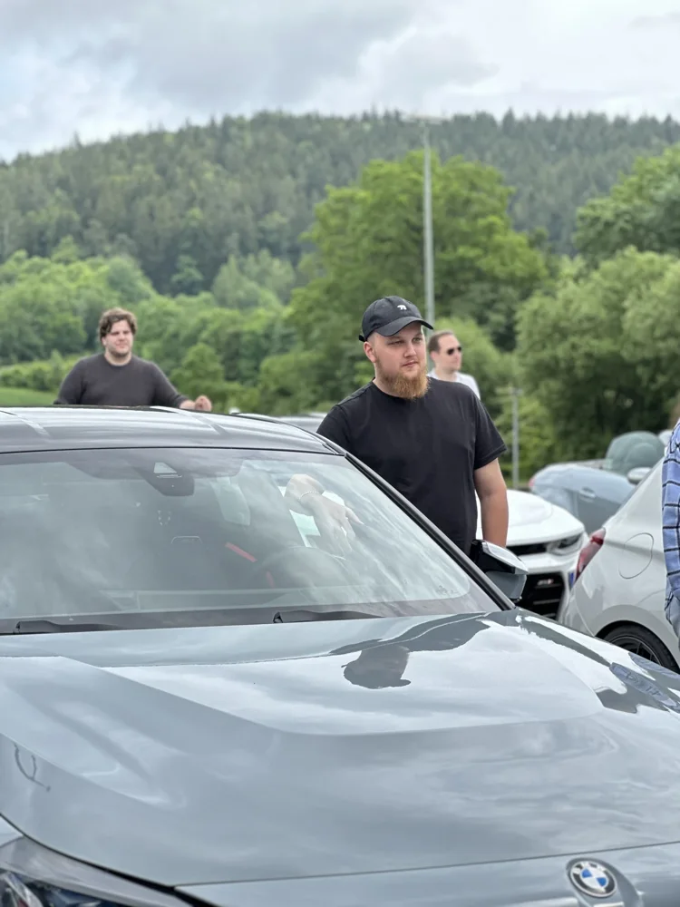 Teilnehmer im Gespräch zwischen den Sportwagen