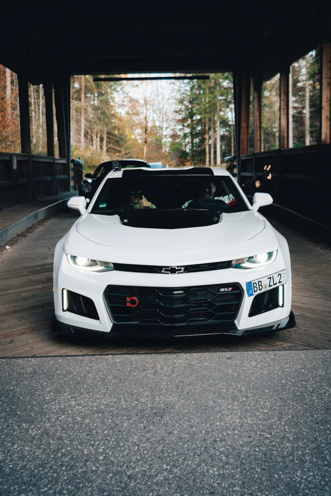 Weißer Chevrolet Camaro unter einer überdachten Zufahrt
