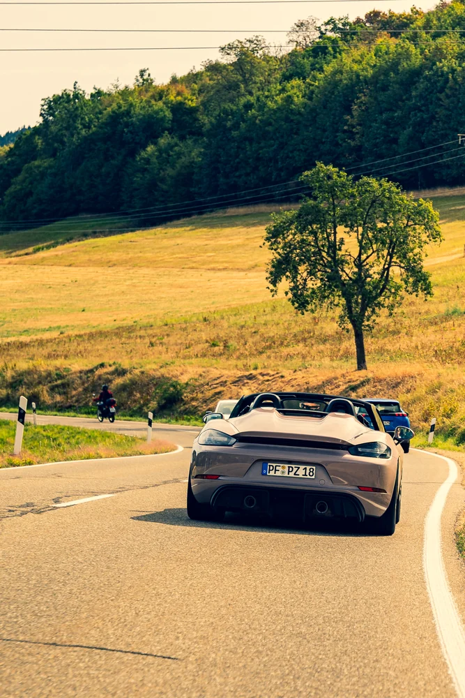Offener Porsche auf der sonnigen Landstraße