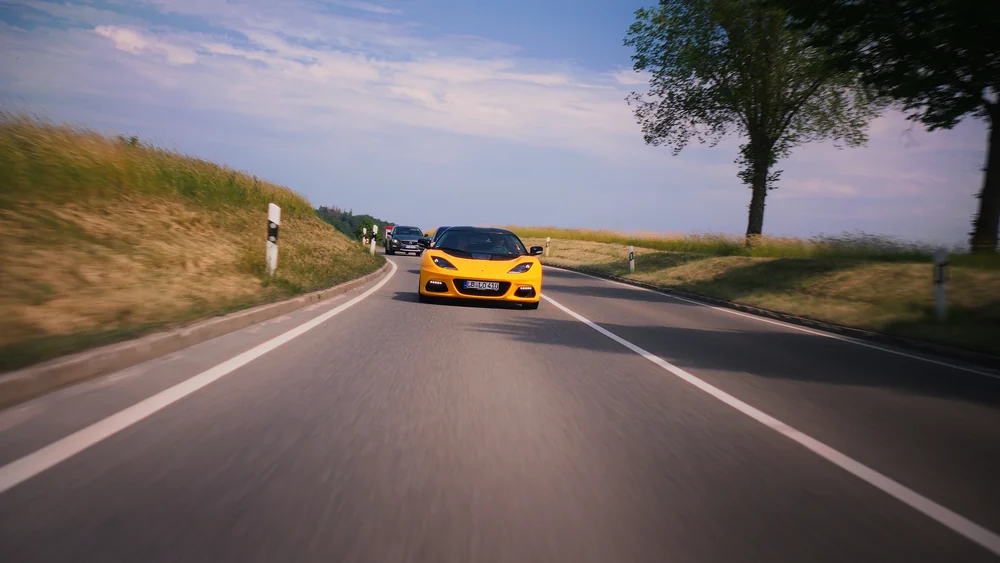 Gelber McLaren zwischen Feldern und Kurven