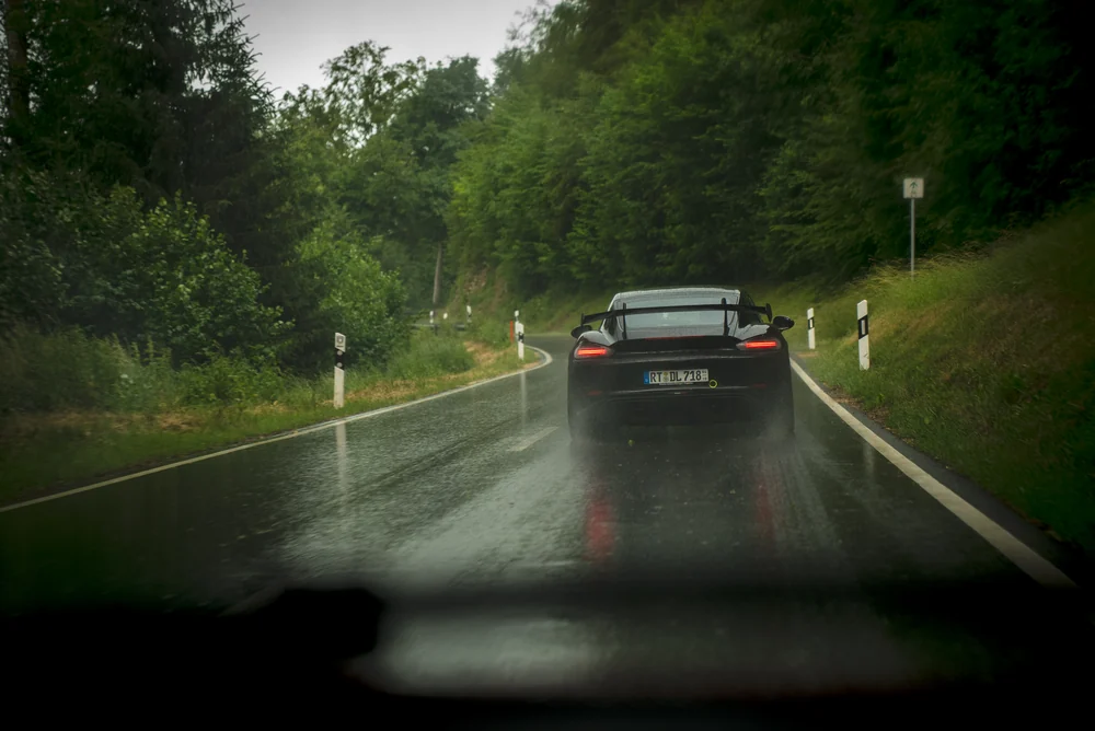 Porsche auf der Waldstraße im Sommerregen