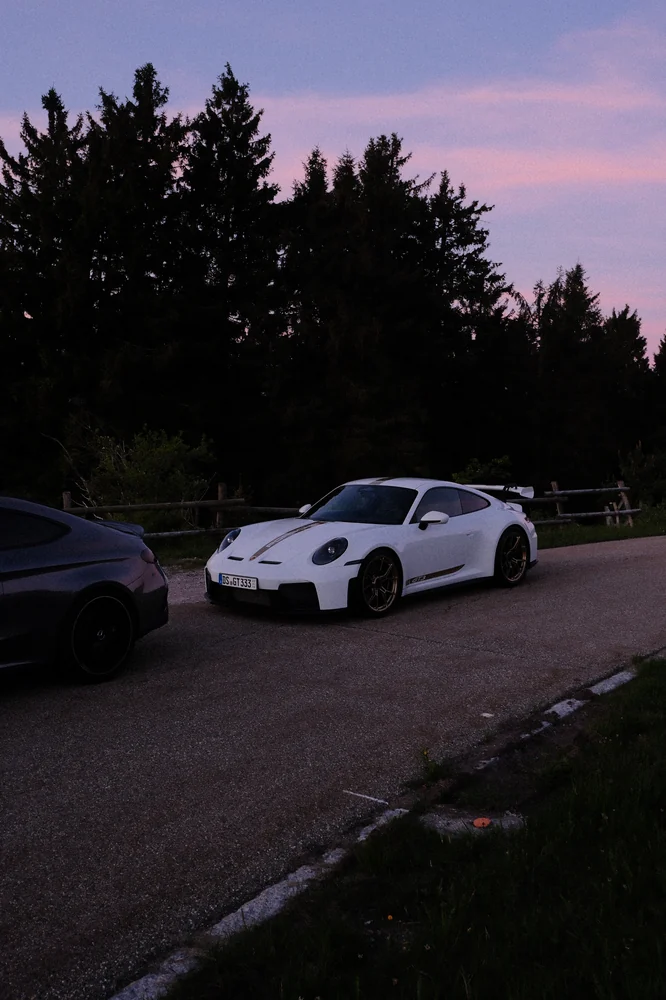 Weißer Porsche 911 vor dem Morgenhimmel