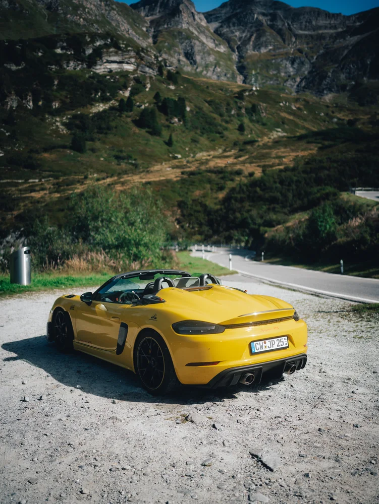 Gelber Porsche Spyder RS an einem alpinen Aussichtspunkt