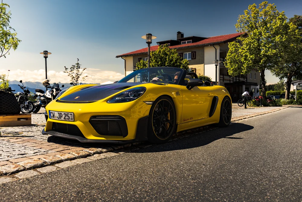 Gelber Porsche Spyder RS beim sonnigen Tourstopp im Alpenort