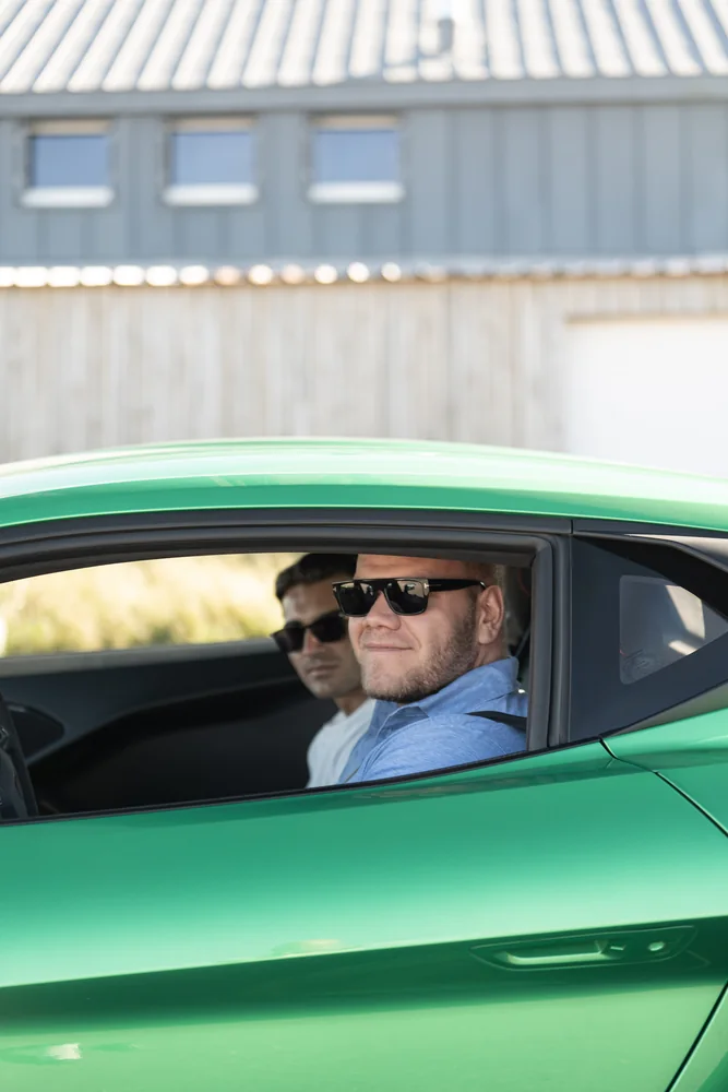 Teilnehmer am Steuer seines grünen Porsche